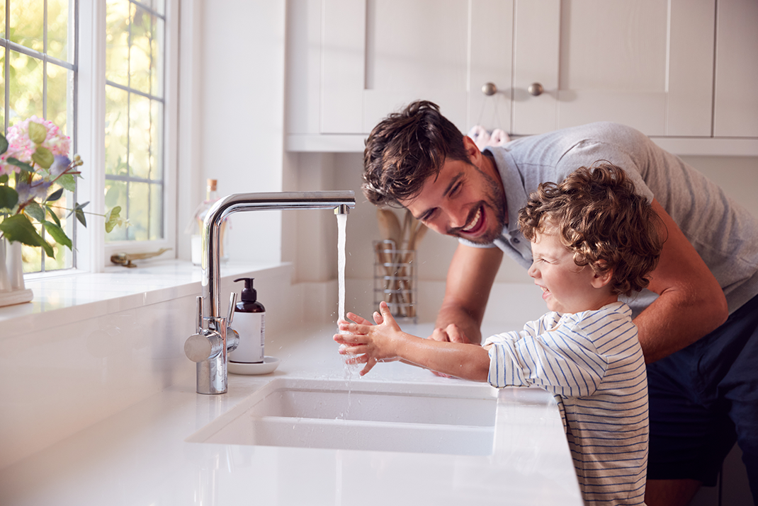 Dad helping his son wash his hands at the kitchen sink | Sinks | Granite World|